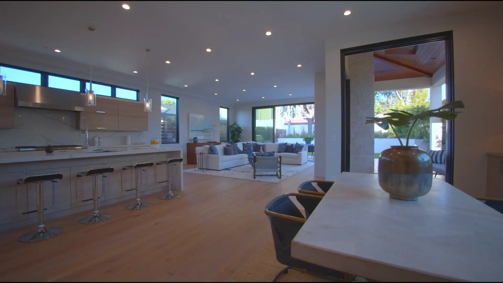 Interior de casa con ventanas de aluminio grandes hacia el patio